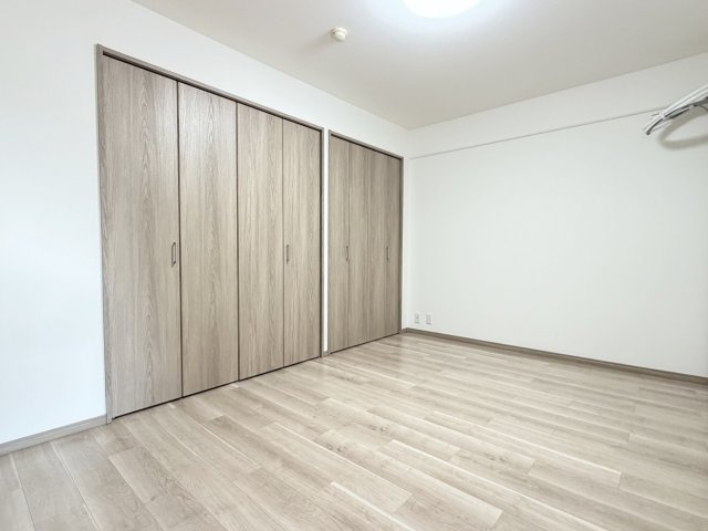サンシティ桂坂参番館の洋室|木目の自然な模様や落ち着きある色味が、お部屋に温かみをもたらします。壁紙は白を基調としており、インテリアプランも考えやすいシンプルな仕上がりです。（R8.8撮影）