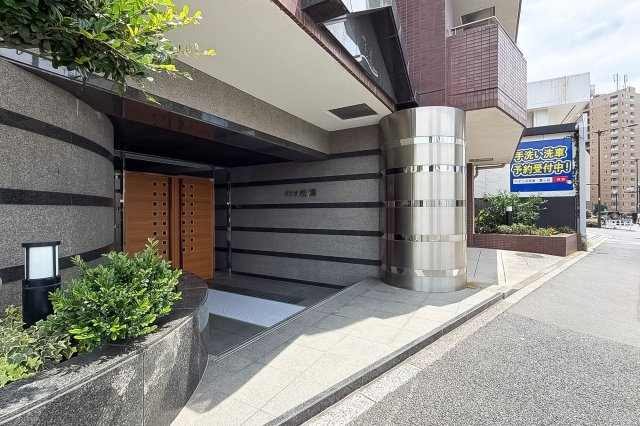 【エントランス】 | パウゼ松濤 | 緑の植栽と上品なタイル壁が美しく調和するエントランス！段差のないスロープ付きで出入りもスムーズです♪