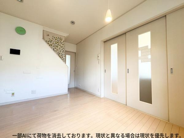 大字森町　戸建ての居間・リビング|明るいフローリングが開放感を演出しています。壁や扉もホワイトで統一されすっきりとした印象です。天井のペンダントライトがアクセントになっています。