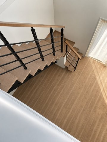 天理市別所町中古戸建のその他|開放感あふれるリビング階段。木の温もりとブラックアイアンの手すりが調和した、スタイリッシュなデザインです。