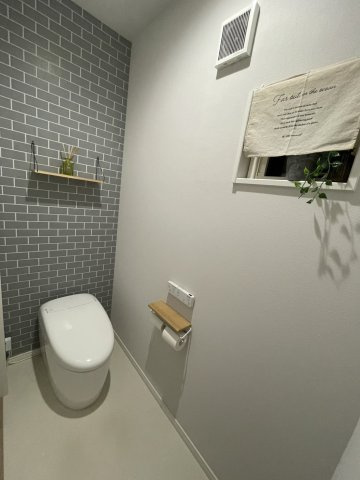 天理市別所町中古戸建のトイレ|グレータイル調クロスがおしゃれなタンクレストイレ。