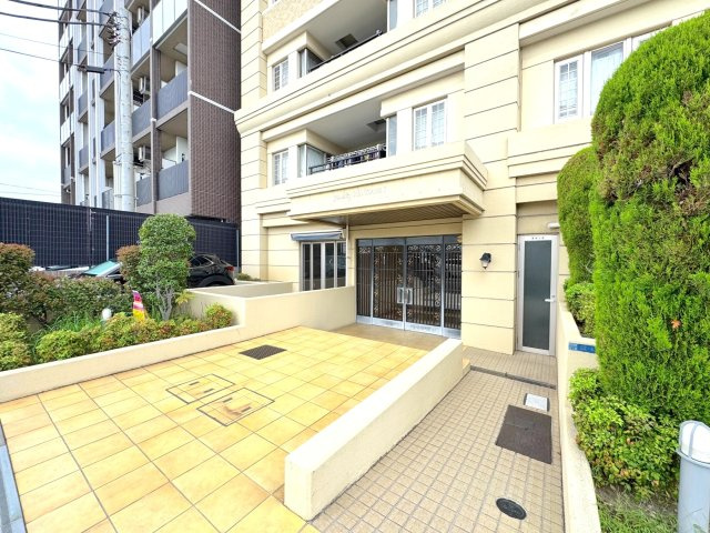 グランシティ新小岩２|【重厚感のあるマンション外観】タイル貼りで落ち着いた雰囲気のエントランスアプローチ。手入れが行き届いた植栽が、住まう方や来客を優しく迎え入れてくれます。