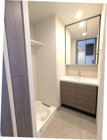 J.GRAN Court上野入谷の洗面所|トイレと独立した洗面脱衣室、2面鏡付ハンドシャワー付洗面台、洗濯機置場は排水口のお手入れしやすい様に手前中央に配置し、足高の防水パンです