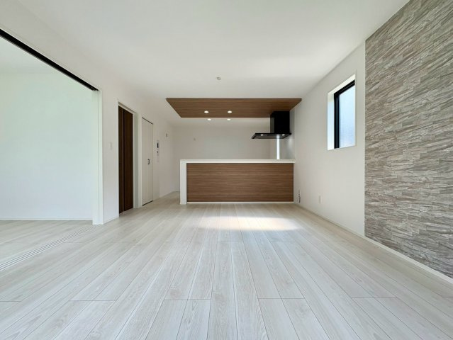 「駐車3台可能」高知市介良乙11期2号棟　新築一戸建ての居間・リビング|おしゃれなアクセントクロスが映える大空間LDK！対面キッチンで会話を楽しみながら料理できます。
