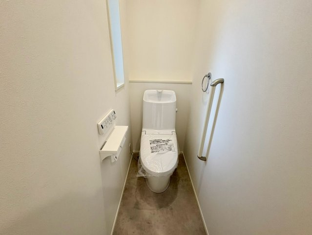 「スキップフロアと吹き抜けがある4LDK」高知市介良乙1号地　新築一戸建てのトイレ|忙しい朝にも重宝する2階トイレ！窓からの自然光と手すり付きで安全・衛生的な空間。