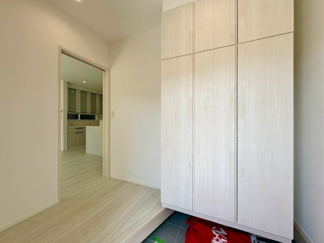 「スキップフロアと吹き抜けがある4LDK」高知市介良乙1号地　新築一戸建ての玄関|大型シューズボックスを備えた清潔感のある玄関！家族全員の靴をスッキリ収納していつでも綺麗な空間。