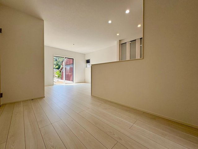 「スキップフロアと吹き抜けがある4LDK」高知市介良乙1号地　新築一戸建ての居間・リビング|自然光がやさしく差し込む大空間！奥のお庭へもそのまま繋がる、開放感たっぷりの憩いリビング。