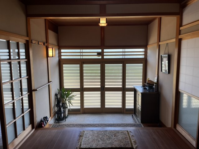 榛原大貝の玄関|格子戸から柔らかな光が差し込む、風情ある玄関ホール。訪れる人を優しく迎える設えです。
