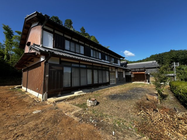 榛原大貝の外観|黒い格子窓と白壁のコントラストが美しい佇まい。広々とした庭スペースも魅力の一つです。
