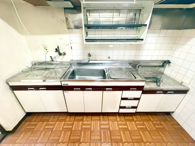 八戸ノ里グランドマンションB棟のキッチン|作業スペースをしっかり確保した壁付けキッチン。収納も上下に備わっており、調理器具や食器を整理しやすい設計です。独立感があるため、生活空間から調理スペースを分けて使えます。