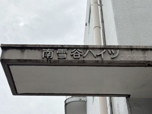 【現況写真】 | 南雪谷ハイツ | エントランスに掲げられた、マンション名を示す館銘板。さほど激しく主張はしませんが、しっかりと掲示されています。～即日のご見学可能～　お問合せはお気軽にどうぞ。