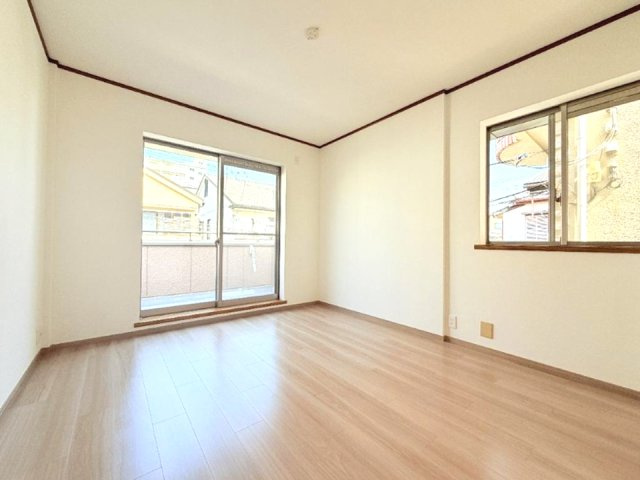 宮塚町の洋室|木目のフローリングが暖かみのある室内に。明るい寝室で心地のいい朝を迎えられそう。