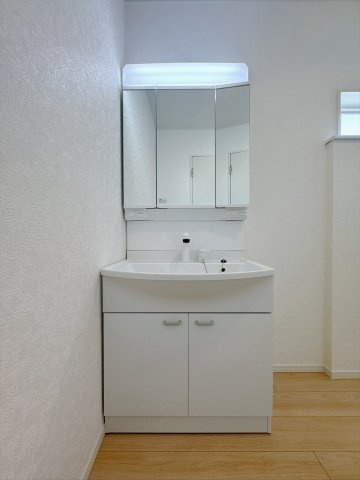 【新築戸建】佐野市天神町第5の独立洗面台|■洗面室｜三面鏡の洗面台は鏡の裏が収納ポケットになっているので、ヘアケア用品や歯ブラシなどでごちゃつきがちな洗面台周りがスッキリ片付きます。　