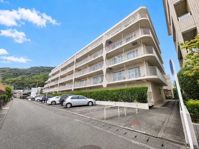第2大岩ハイデンスの外観|青空と緑豊かな山々を背景に佇むマンション。白を基調とした外観が爽やかな印象を与えます。