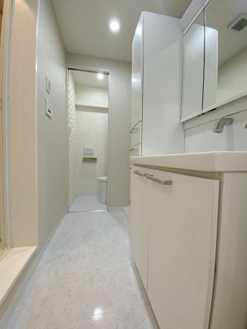 習志野台マンションの脱衣所|しっかりとした広さが確保された快適な脱衣所スペースです。脱衣カゴやランドリーラックを置いても窮屈感を感じさせず、朝の身支度や入浴後もゆったりストレスフリーにご利用いただける設計となっています。