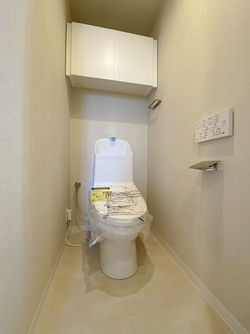 アーバネスト船橋三咲のトイレ|快適な温水洗浄便座付きのトイレに新規交換いたしました。お手入れがしやすい衛生的な最新モデルを採用。吊戸棚や省スペース収納を活用すれば、トイレットペーパー等の備品もすっきりと整理収納可能です。