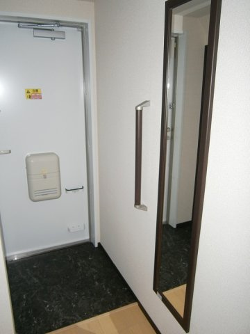クレイノサンライズステージの玄関|姿見付きの玄関。ドアには傘立ても。