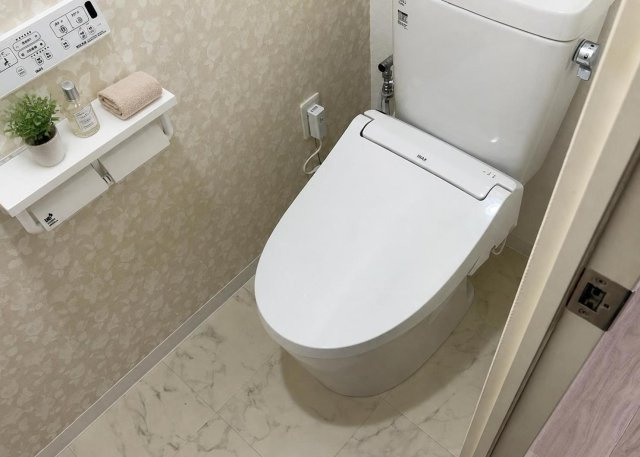 【トイレ】 | ユニヴェルシオール学園の丘 | 2026年7月のリフォームにて新調された快適なトイレ空間です。壁や天井のクロスもきれいに貼り替えられており、清潔な印象を与えます。毎日の生活で頻繁に使う場所だからこそ、使い勝手にこだわっています。