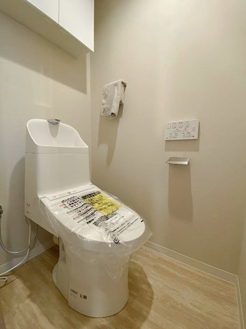 サニータウン習志野台サンハイツのトイレ|快適な温水洗浄便座付きのトイレに新規交換いたしました。お手入れがしやすい衛生的な最新モデルを採用。吊戸棚や省スペース収納を活用すれば、トイレットペーパー等の備品もすっきりと整理収納可能です。