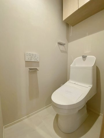 ライオンズステージ平井のトイレ|快適な温水洗浄便座付きのトイレ設備へ新規交換いたしました。掃除がしやすく衛生的な仕様となっており、上部にはペーパー類や掃除用品の保管に便利な棚も備わった機能的で清潔感ある空間に仕上げています。