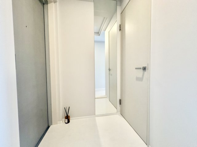 リベール住吉パークフィールドの玄関|お出かけ前の身だしなみチェックがスムーズにこなせる大型の姿見鏡を壁面に設置。空間を視覚的に広く見せる効果もあり、限られた玄関まわりの出入り口をいつでもすっきりとクリーンな状態にキープできます。