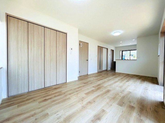 緑区大形山　売戸建の居間・リビング|温かみのある木目調のフローリングと各部屋へと続くドアが、全体に統一感と落ち着きをもたらします。