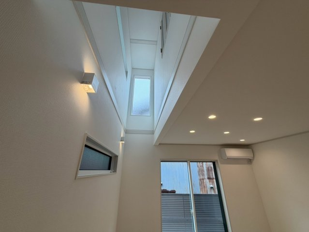 笠松町松栄町Ⅱ分譲の居間・リビング|リビング吹抜け：南の開口から明るい光が降り注ぎます。主寝室の小窓と繋がっています。