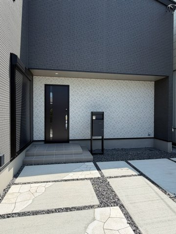 岐阜市西荘分譲A棟の玄関|玄関アプローチ：ツートンカラーのホワイト外壁で玄関の存在感を強調しています。家の“第一印象”を彩る玄関ポーチ。現地西側道路より（2026年8月）撮影 