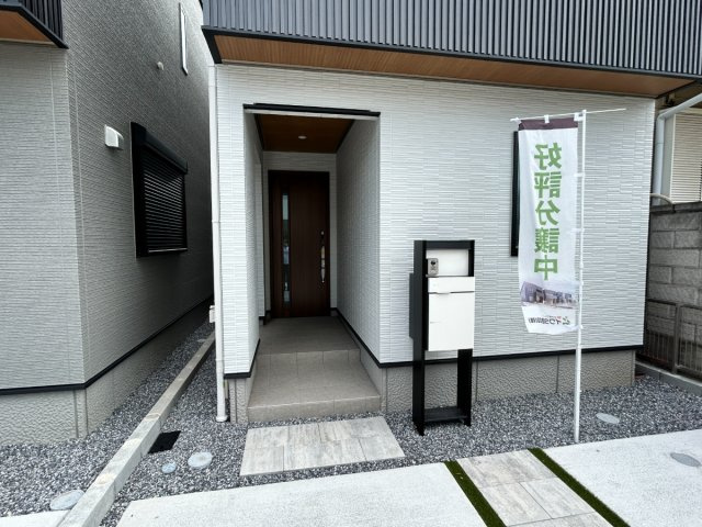 岐阜市加納南陽町分譲A棟の玄関|玄関アプローチ：ツートンカラーのホワイト外壁で玄関の存在感を強調しています。家の“第一印象”を彩る玄関ポーチ。現地北側道路より（2026年8月）撮影 