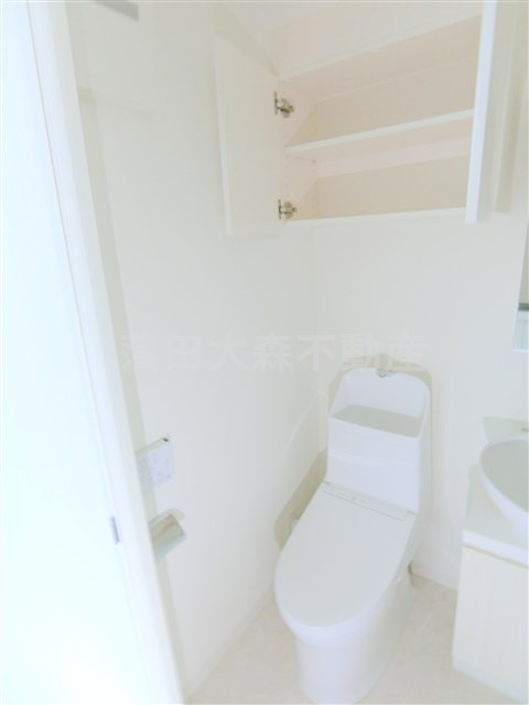 ベルシード千鳥町のトイレ|吊戸棚と温水洗浄便座付きのトイレ