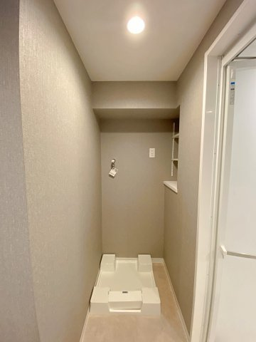 ライオンズマンション市川広尾のランドリースペース|洗濯機置場周辺には洗剤や日用品を置けるスペースが確保されており、スムーズに洗濯作業を行える設計です。日々の家事負担を大幅に軽減し、いつでも清潔感あふれる快適な空間を維持していただけます。