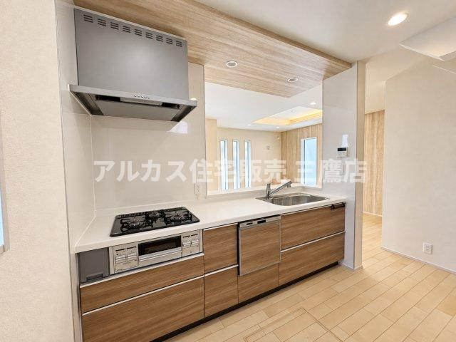三鷹市井口4丁目 西武多摩川線 新小金井駅 新築戸建のキッチン|温かみのある木目デザインのキッチンキャビネット。リビングのご家族と会話を楽しみながら家事ができる開放的なレイアウトです。