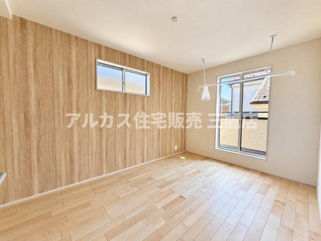 三鷹市井口4丁目 西武多摩川線 新小金井駅 新築戸建の洋室|木目調の壁紙がおしゃれなアクセントになった洋室。バルコニーに面した大きな窓から心地よい自然光が入ります。