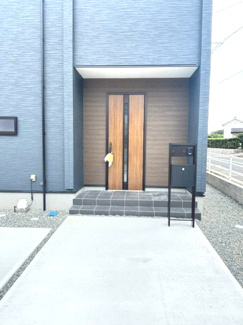 【玄関】 | 東広島市高屋町高屋東（全2区画）2号棟 | 木目調の玄関ドアがアクセントになった落ち着きのある玄関ポーチ。屋根付きのアプローチで、雨の日の移動や荷物の積み下ろしもスムーズです。
