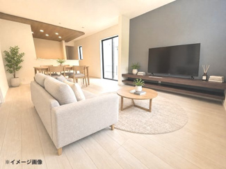 【居間・リビング】 | 東広島市高屋町高屋東（全2区画）2号棟 | 木目調の天井が温かみを添えるリビング。アクセントクロスと折り上げ天井に設けたコーブ照明が上質な空間を演出します。ダウンライトも配され、シーンに合わせてライティングを調整可能です。