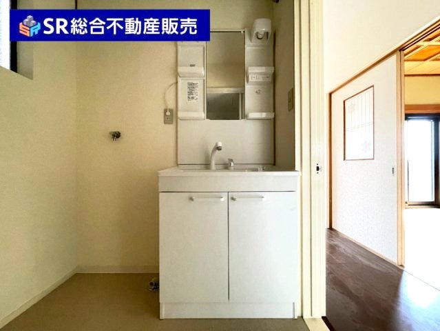 上六万寺町中古戸建の独立洗面台|シャワー付きで、両サイドと下部に小物収納があり便利です。
