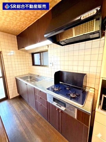 花園東町2丁目中古戸建のキッチン|3口コンロ、グリル付きのシステムキッチンで快適にお料理できます！（室内写真は加工により家具等を消しています。）