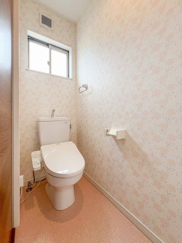 結城市山川新宿のトイレ|淡い花柄のクロスで優しい雰囲気に仕上げた2階トイレ。温水洗浄便座や窓を備え、換気にも配慮されています。