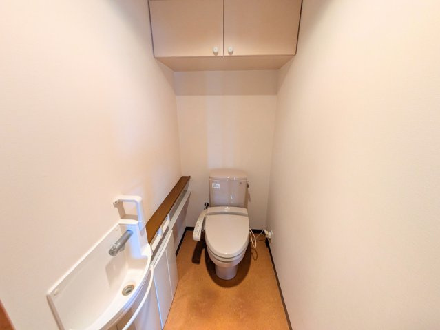 PEACEマンション山越のトイレ|手洗い器と吊戸棚を備えた快適なトイレ空間。トイレットペーパー等の備品も綺麗に収まります。