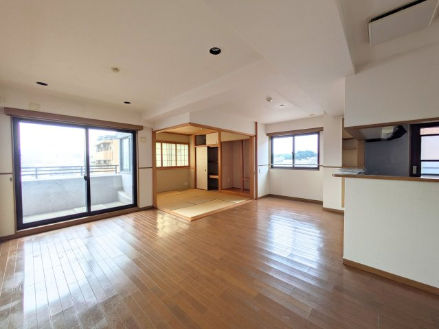 PEACEマンション山越の居間・リビング|大きな窓から光が差し込む広々としたリビング。和室が隣接し家族で寛げる開放的な空間です。