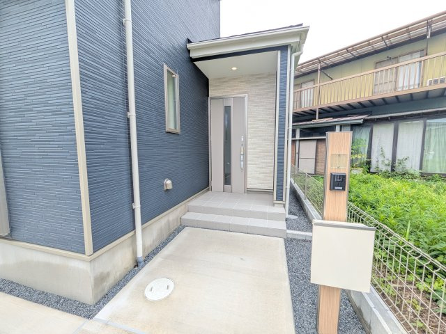 石岡市石岡2396番　新築戸建　A号棟の玄関|お洒落な玄関ドアと洗練された外壁デザイン。家の顔にふさわしい上質な佇まいで、ご家族やお客様を迎えます。