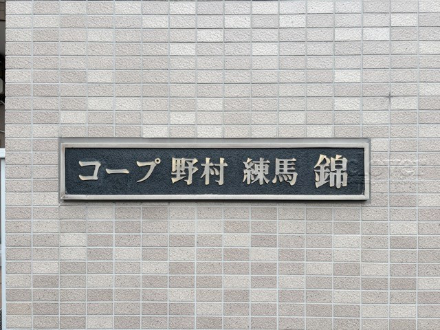 【現況写真】 | コープ野村練馬錦 | エントランスに掲げられた、マンション名を示す館銘板。さほど激しく主張はしませんが、しっかりと掲示されています。～即日のご見学可能～　お問合せはお気軽にどうぞ。