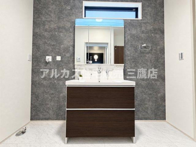 三鷹市大沢5丁目 京王線 調布駅 新築戸建の独立洗面台|スタイリッシュなアクセントクロスが印象的な洗面化粧台。三面鏡裏の収納や足元の引き出しなど、洗面小物をスマートに収納できます。