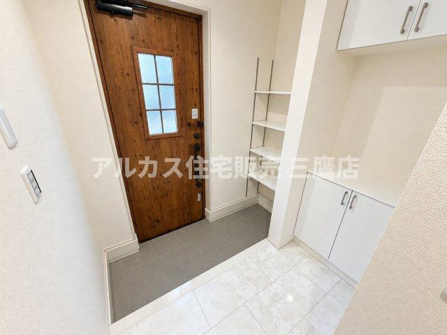 三鷹市大沢5丁目 京王線 調布駅 新築戸建の玄関|明るいホワイト調のタイルフロアが広がる玄関ホール。空間を効率的に活用した収納配置で、いつでも清潔感のある玄関を保てます。