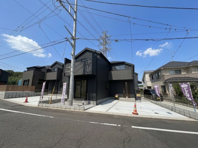 青梅今寺の外観|ブラウンとグレーのツートンカラーがお洒落な新築分譲住宅の外観写真です。 明るい日差しの中で、洗練されたデザインが目を引きます。駐車場スペースもあり、快適な生活が想像できる物件です。