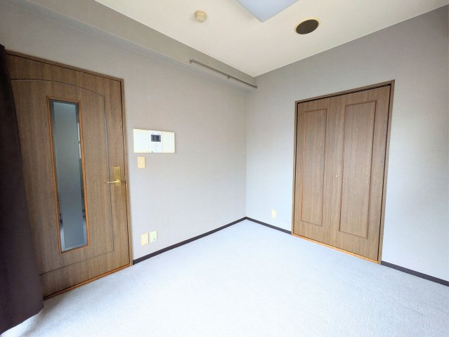 ライオンズマンション宮西壱番館の洋室|ドアやクローゼットの木目調デザインが温もりを演出する、使い勝手の良いシンプルなお部屋です。
