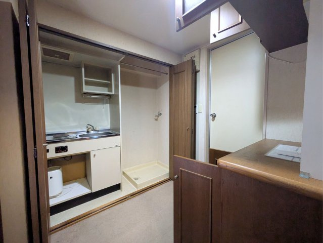 ライオンズマンション宮西壱番館のキッチン|扉を開けるとコンパクトなキッチンと室内洗濯機置場が現れる、空間を効率的に使える設計です。