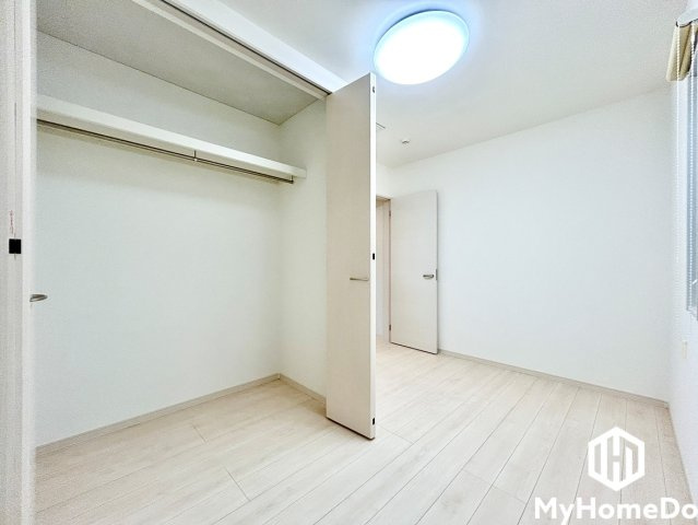 春日井市南花長町の洋室|ハンガーパイプの上には枕棚があり、スーツケースや季節もののバッグ、収納ボックスなどをすっきり整理可能。