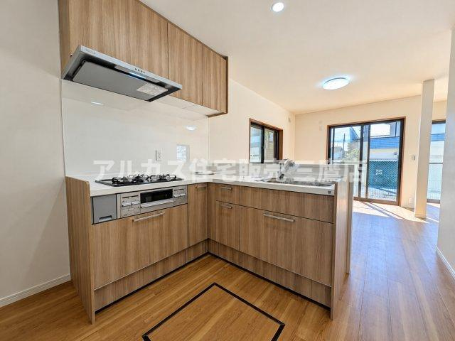 東久留米市前沢3丁目 西武新宿線 花小金井駅 中古戸建のキッチン|お料理中もご家族との会話を楽しめるL字型の対面式システムキッチンで、あたたかみのある木目調のデザインと豊富な収納が魅力です。