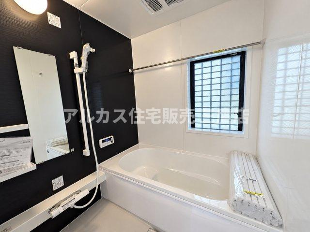 東久留米市前沢3丁目 西武新宿線 花小金井駅 中古戸建の浴室|黒のアクセントパネルがシックで高級感を演出するバスルームです。浴室換気乾燥機や窓を備え、いつでも清潔で快適なバスタイムをお過ごしいただけます。